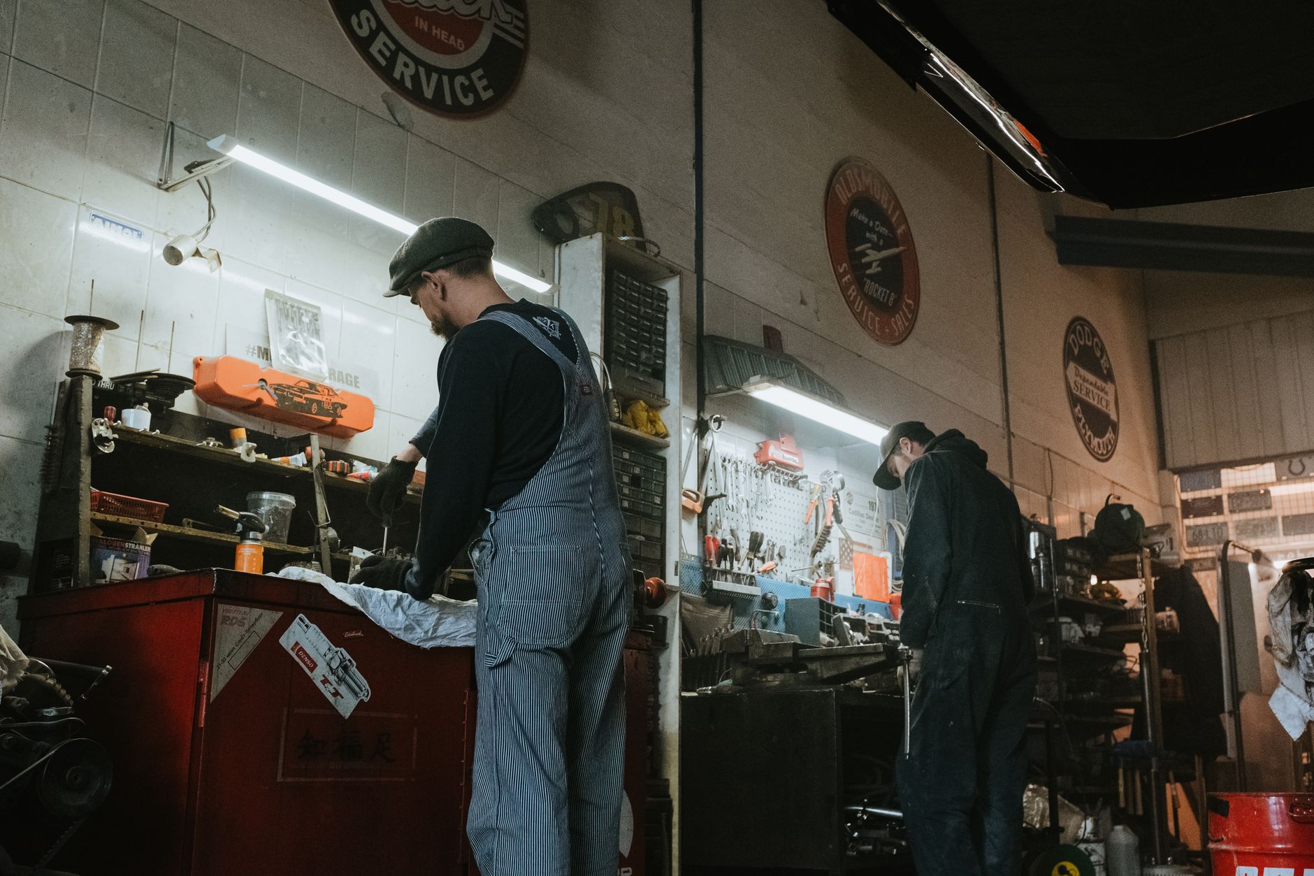 Two mechanics working on a vehicle in an auto repair garage