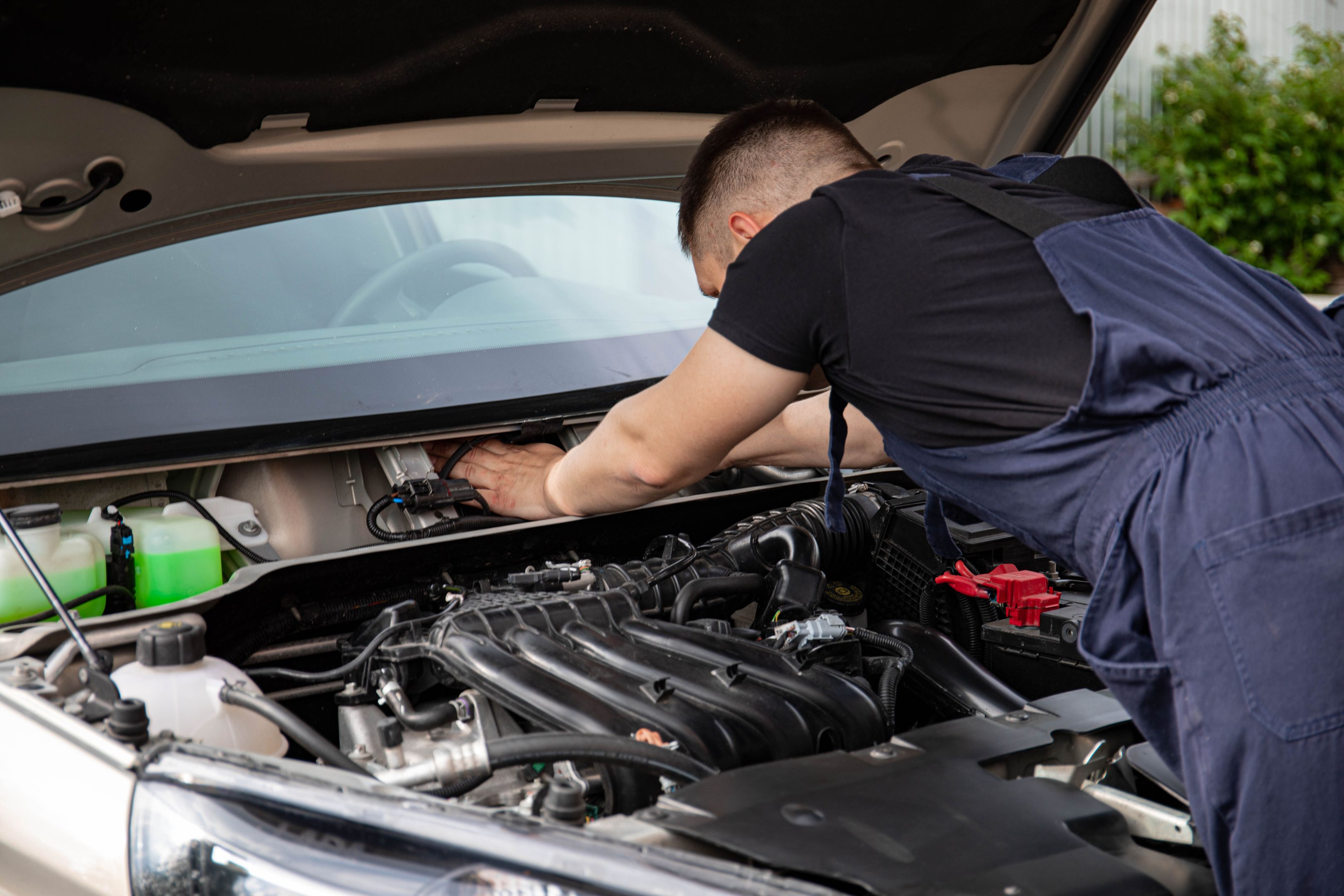 Technician servicing a car engine in an auto repair shop